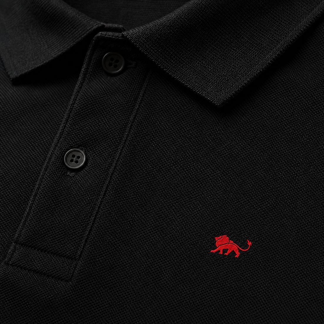 Logo bordada em camisa polo preta, acabamento usado em uniformes de recepção